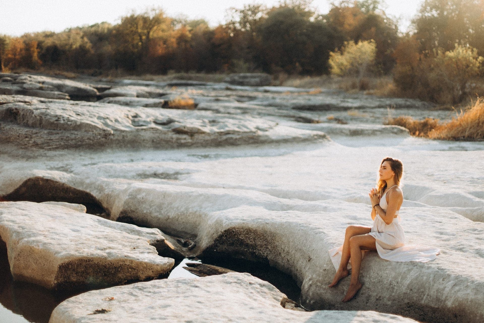 Julia seated in prayer at golden hour on the Texas Hill Country rocks