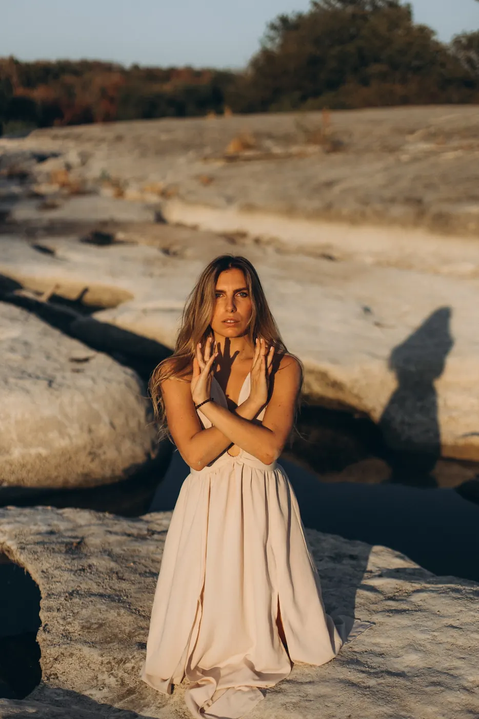 Julia standing on the riverbed with her hands crossed over her heart