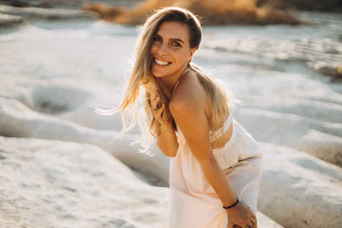 Julia laughing on the riverbank in the evening light