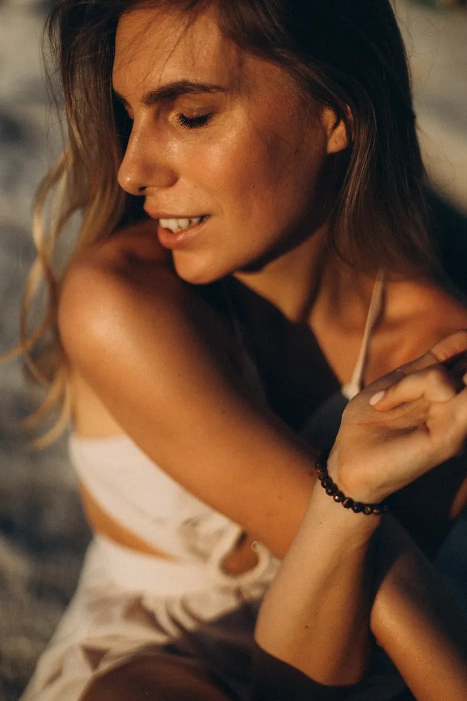 Close portrait of Julia smiling, eyes lowered, in warm evening light