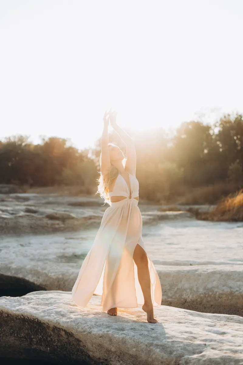 Julia standing in the low sun with her face turned up to the light