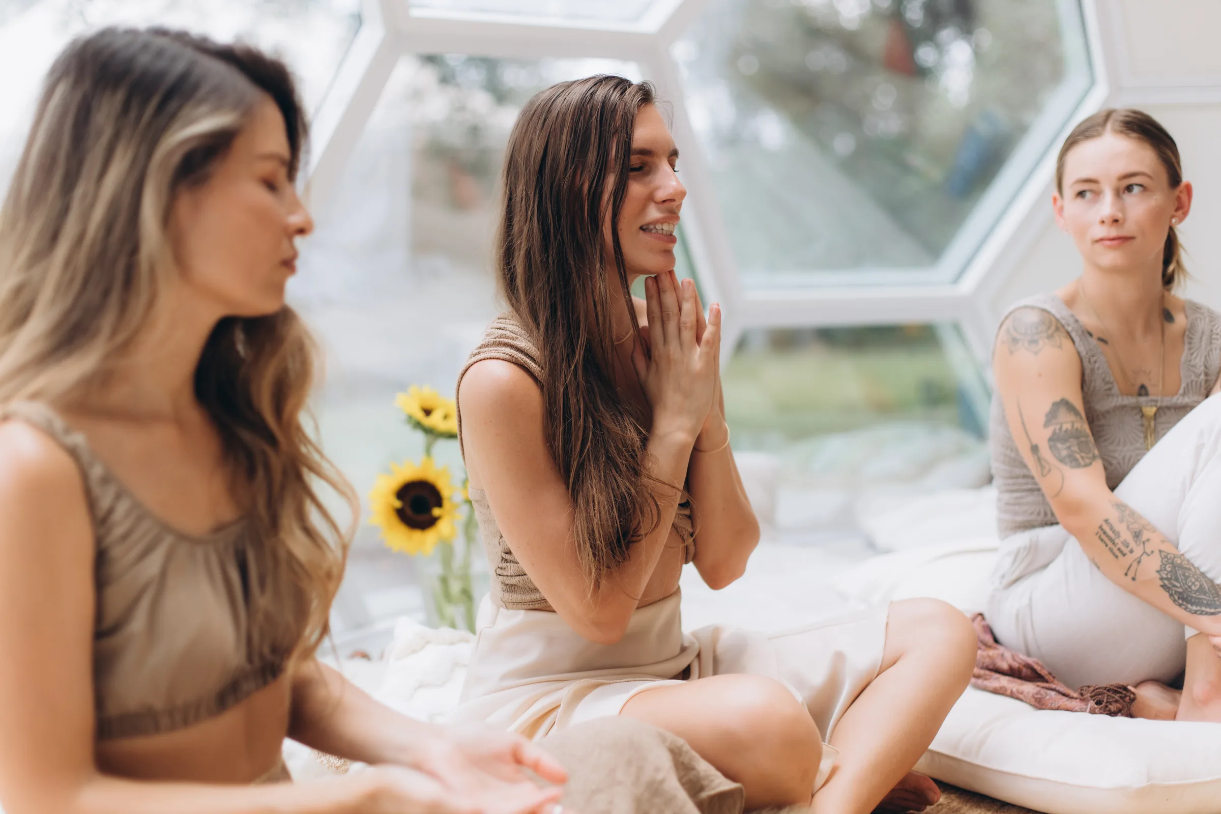 Women sitting in conversation beside sunflowers in the dome