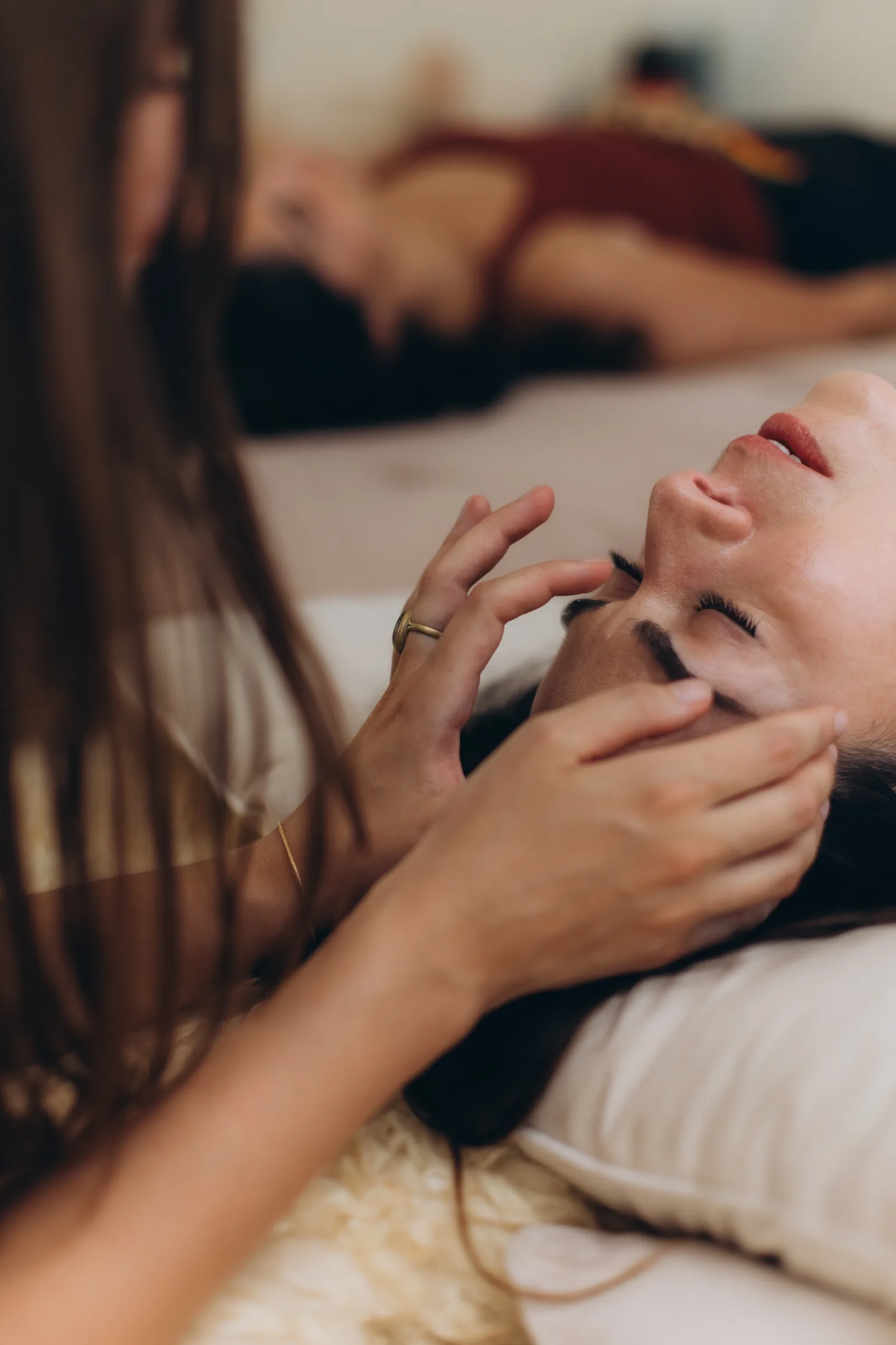 A close frame of hands at a client's cheek and jaw