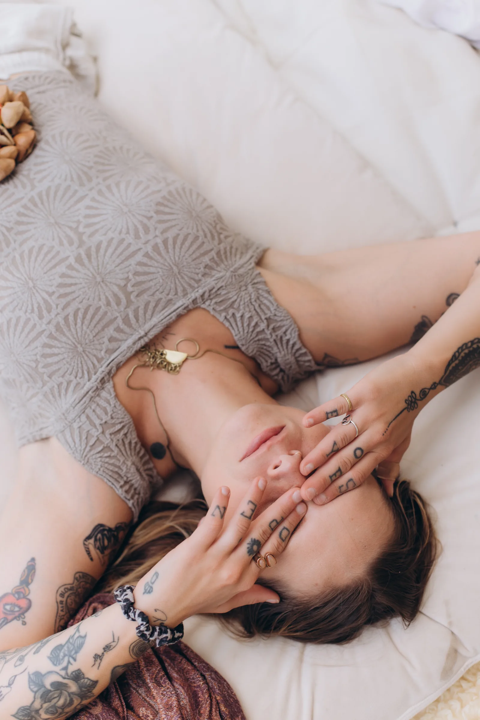 A client resting with hands held gently over her face.