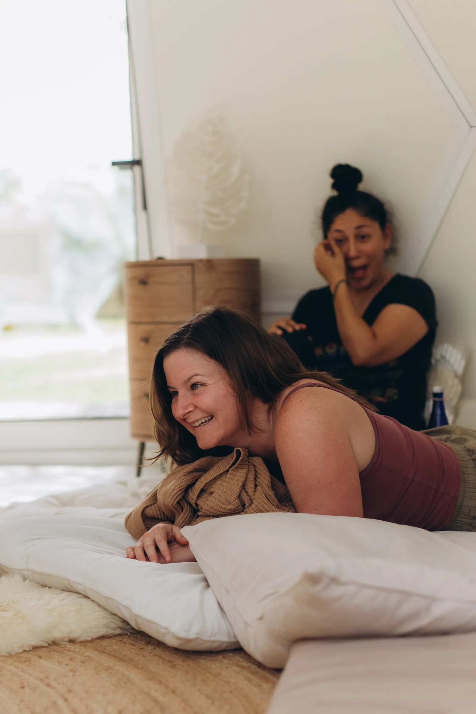A woman resting on her front, laughing, after the session